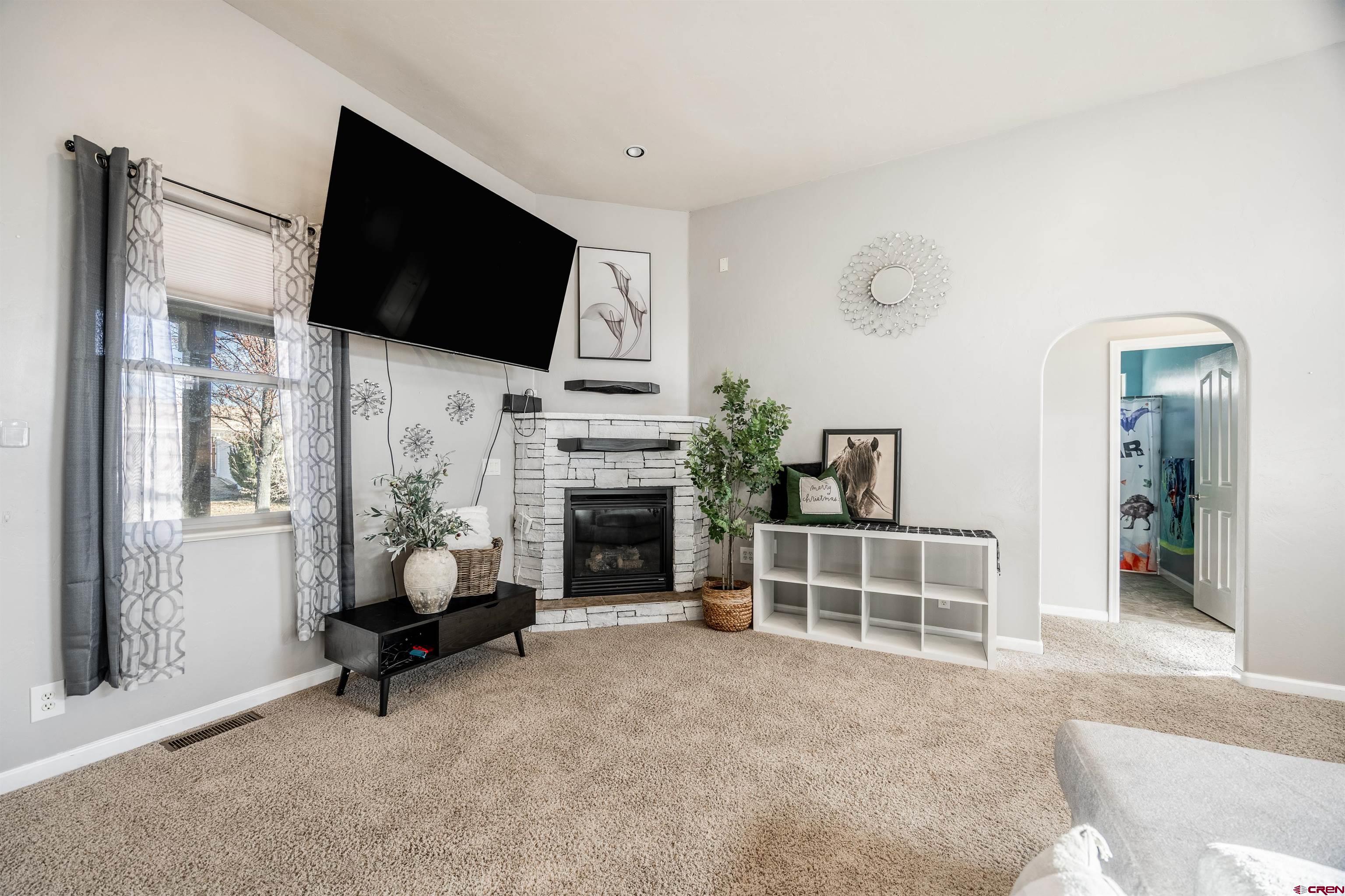 1443 Criterion Street Delta, CO 81416 - Photo 4 of 36 a living room with furniture a flat screen tv and a fireplace