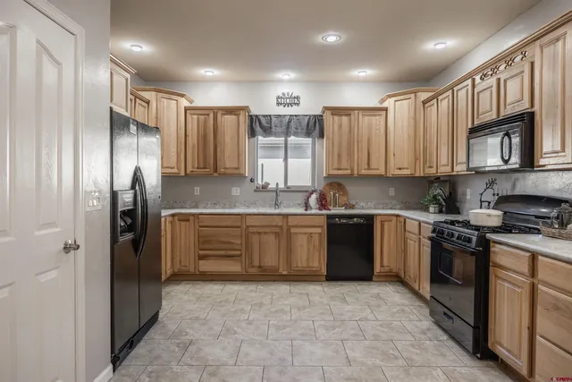 a kitchen with stainless steel appliances granite countertop a refrigerator stove top oven and sink