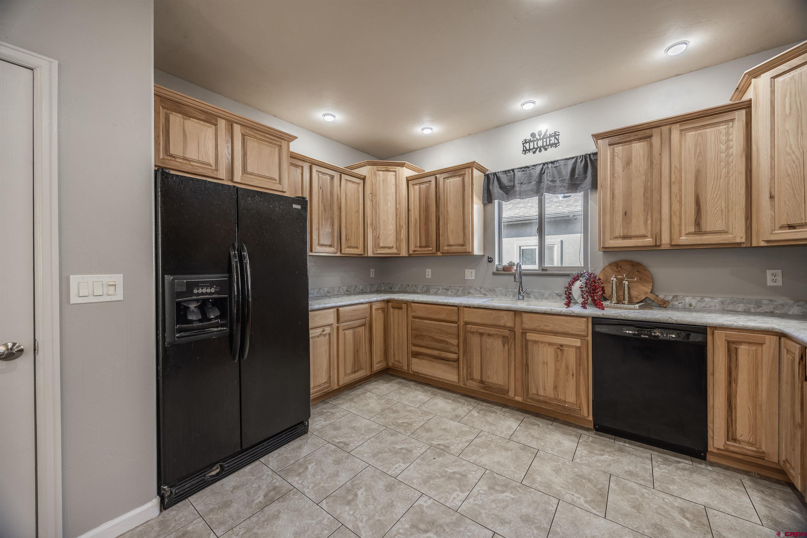 1443 Criterion Street Delta, CO 81416 - Photo 6 of 36 a kitchen with stainless steel appliances granite countertop a refrigerator and cabinets