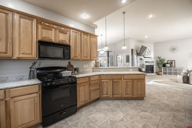 a large kitchen with stainless steel appliances granite countertop a stove a sink dishwasher and a microwave