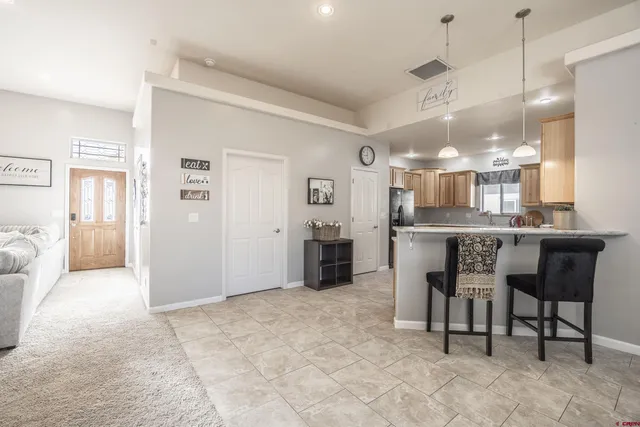 a kitchen with kitchen island a dining table chairs and cabinets