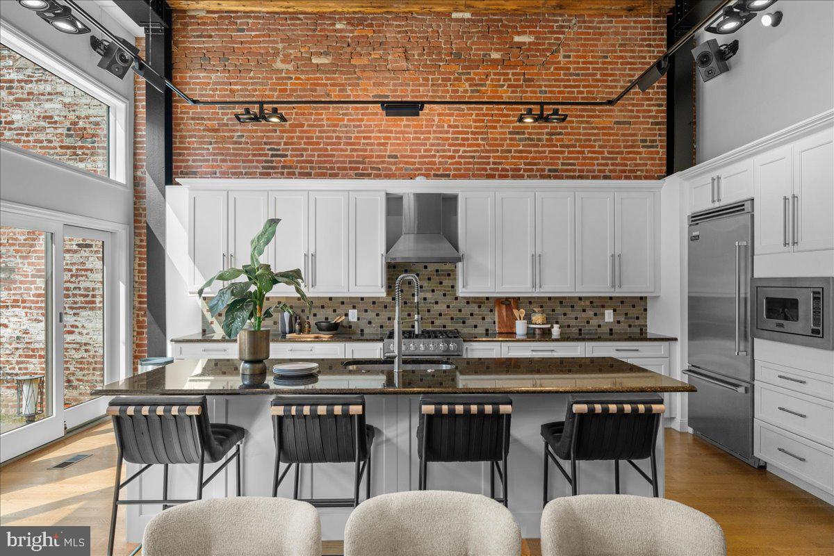 314 Fitzwater Street Philadelphia, PA 19147 - Photo 15 of 51 a kitchen with stainless steel appliances granite countertop wooden floor and white cabinets