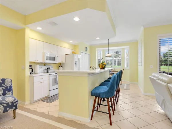 a kitchen with a dining table chairs and large window
