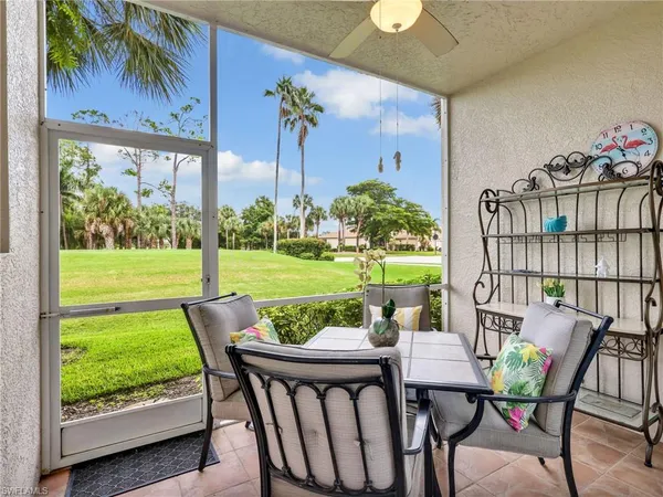 a view of a patio with a table chairs and a backyard
