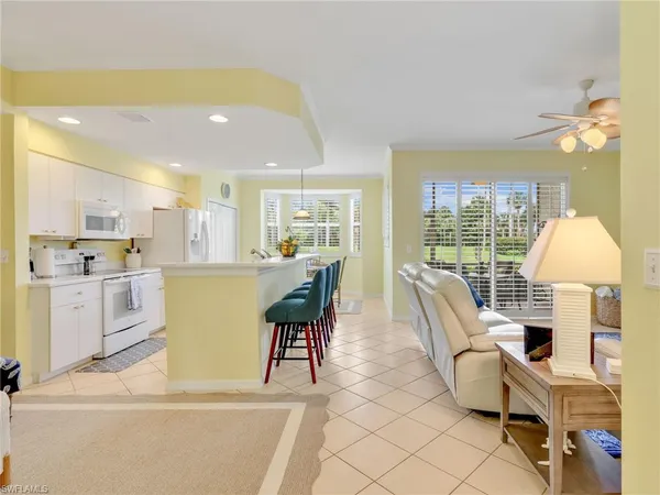 a living room with furniture a table and a large window