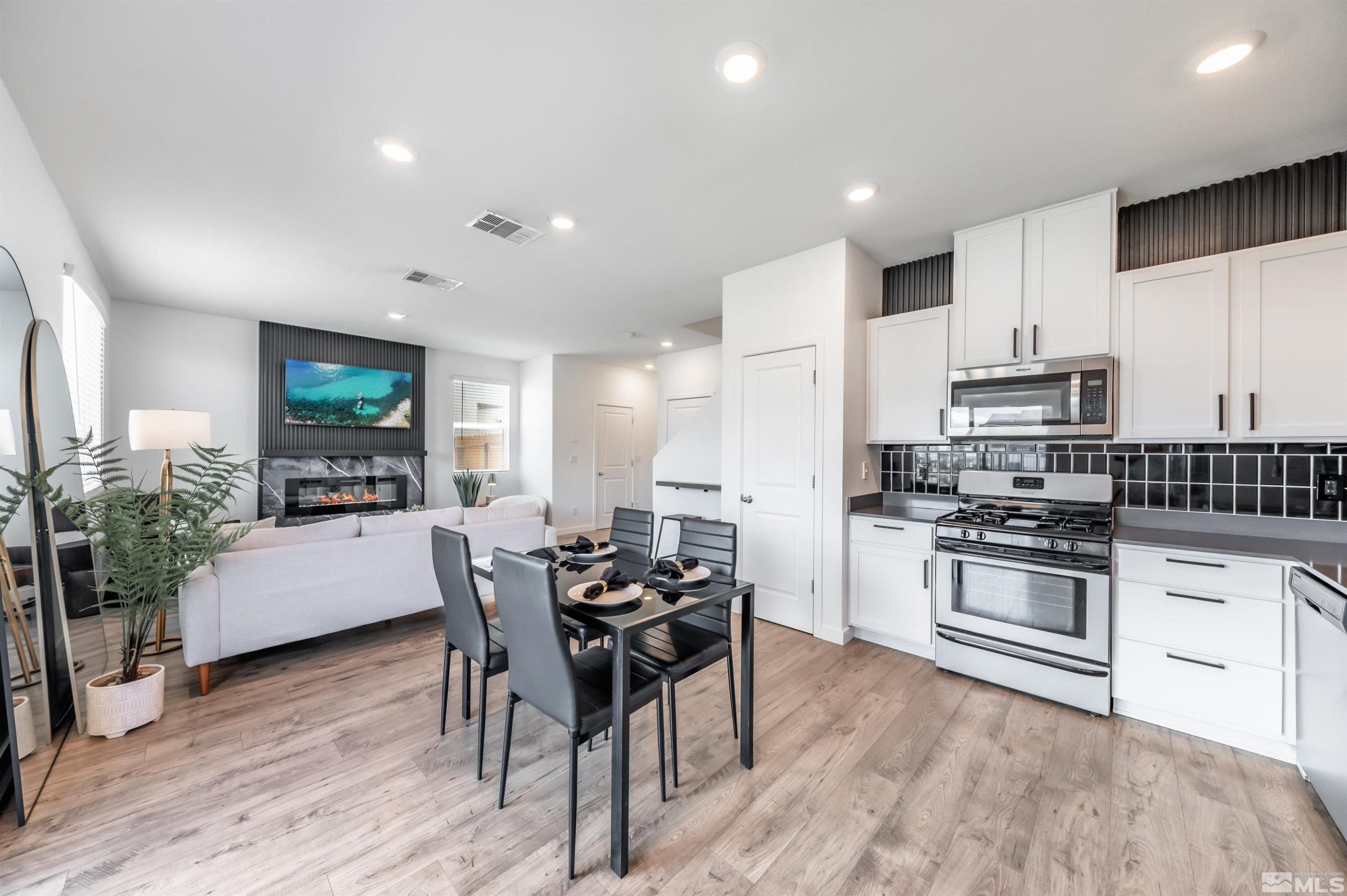 8855 Wolf Moon Drive Reno, NV 89506 - Photo 12 of 35 a kitchen with stainless steel appliances wooden floor dining table and chairs
