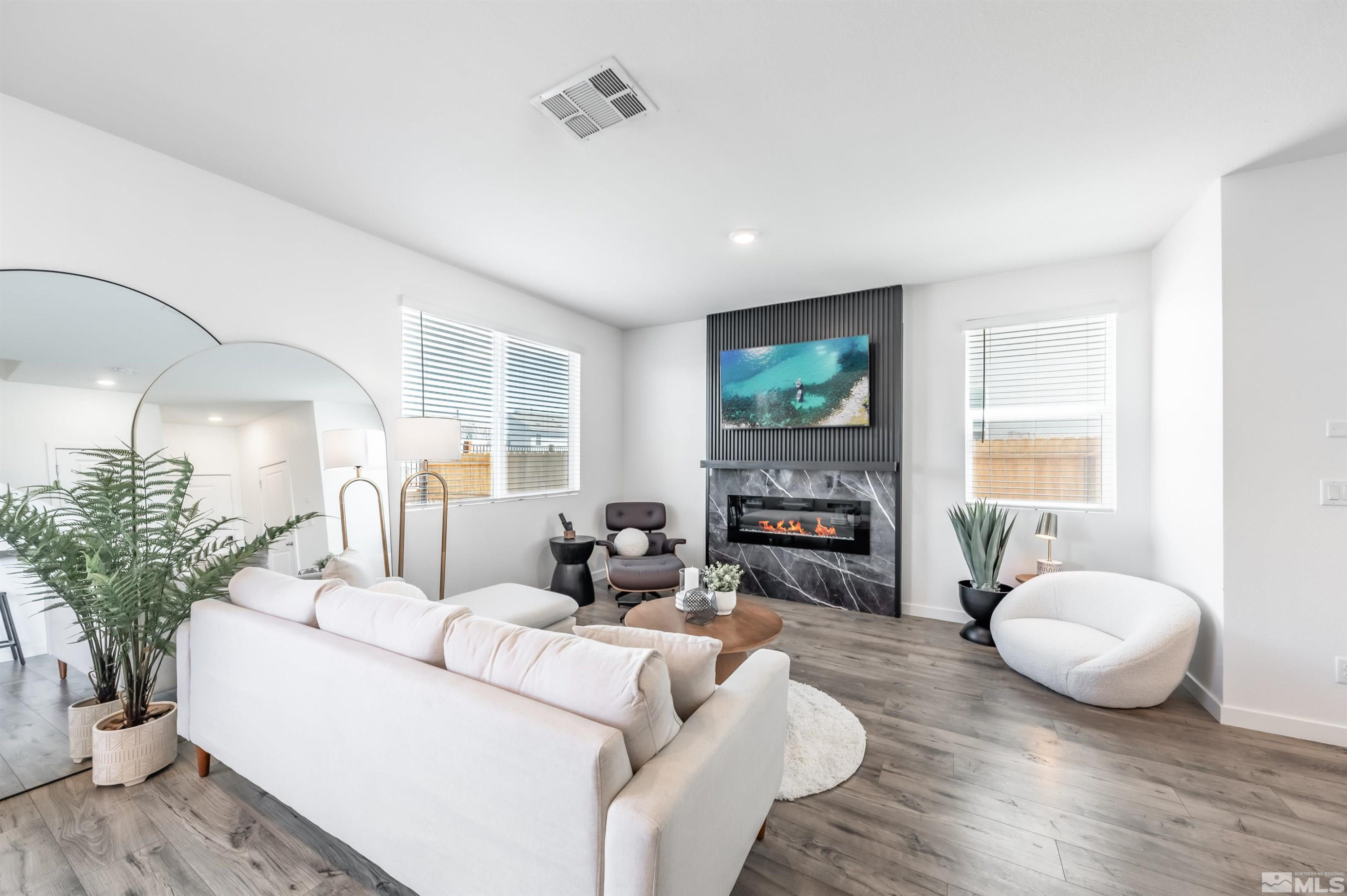 8855 Wolf Moon Drive Reno, NV 89506 - Photo 5 of 35 a living room with furniture a fireplace and a flat screen tv