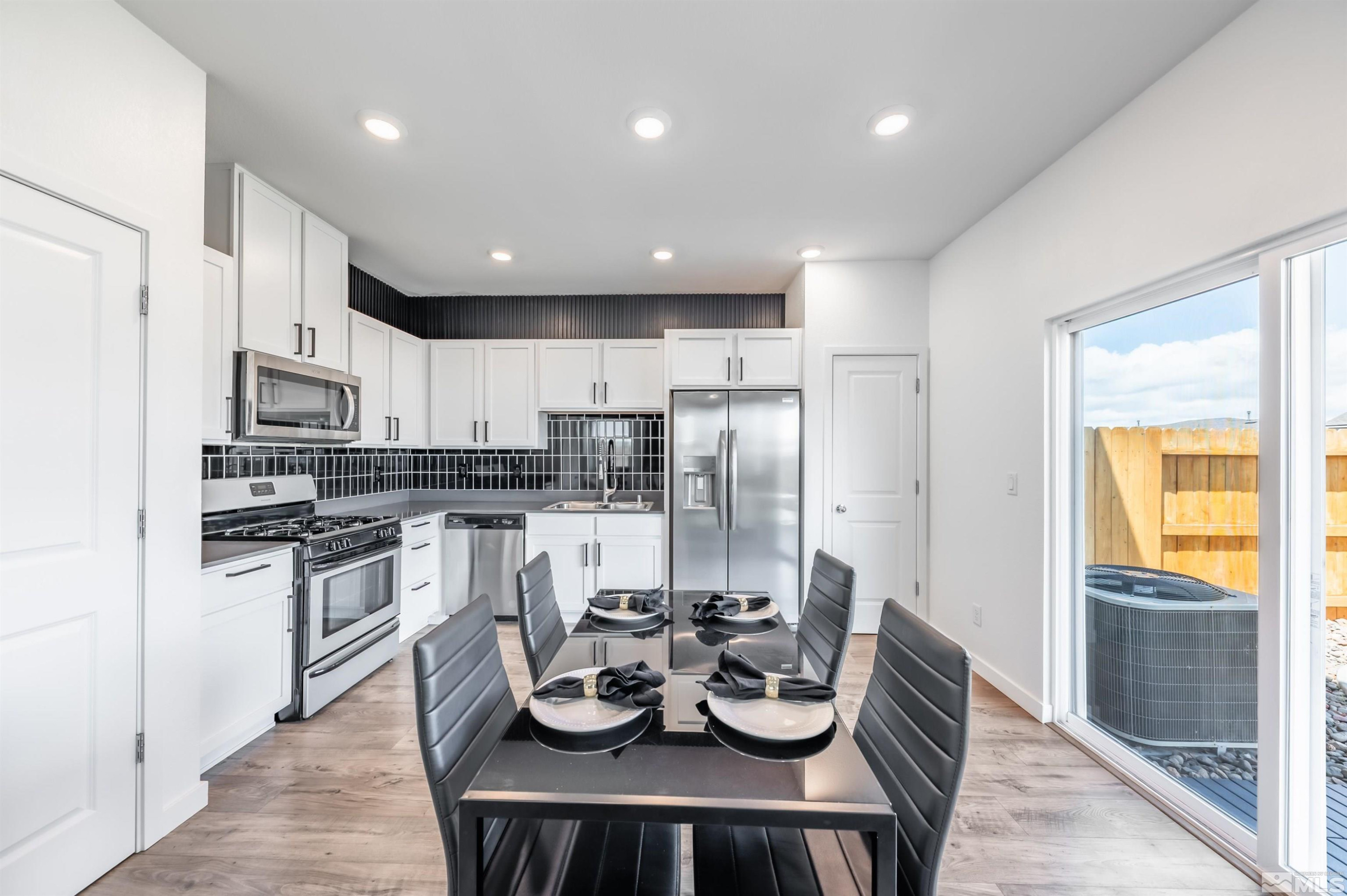 8855 Wolf Moon Drive Reno, NV 89506 - Photo 8 of 35 a kitchen with a refrigerator and a stove top oven