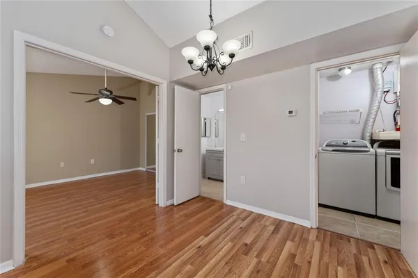a view of a livingroom with a chandelier fan and refrigerator