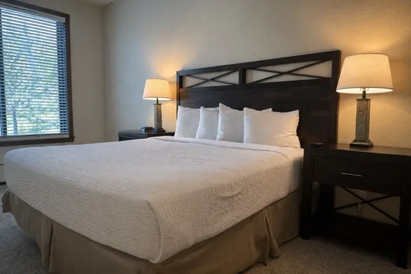a bed sitting in a bedroom next to a lamp
