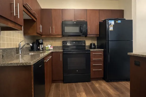 a kitchen with stainless steel appliances granite countertop a refrigerator and a sink