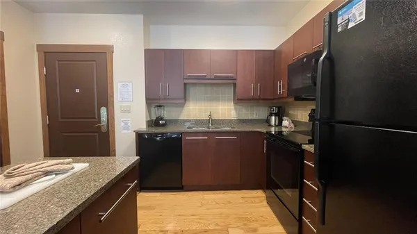 a kitchen with granite countertop a refrigerator and a stove
