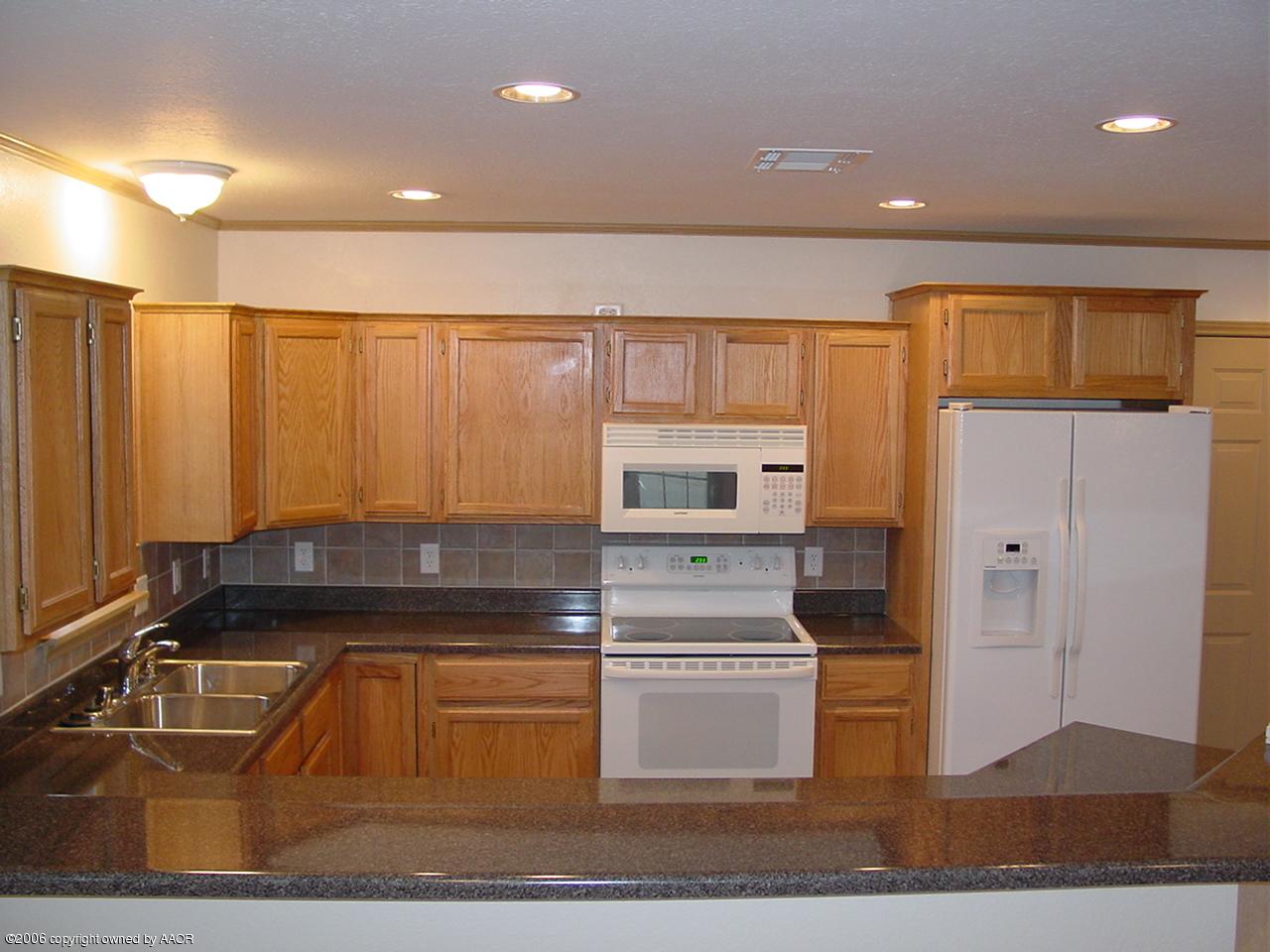 4414 South Austin Street Amarillo, TX 79110 - Photo 3 of 7 a kitchen with kitchen island granite countertop a stove kitchen island a sink and a refrigerator