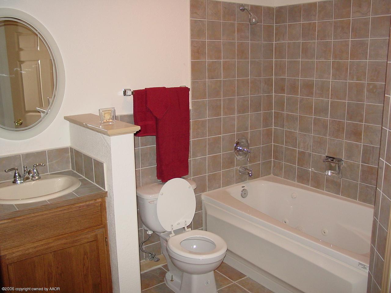 4414 South Austin Street Amarillo, TX 79110 - Photo 5 of 7 a bathroom with a sink a toilet and a mirror