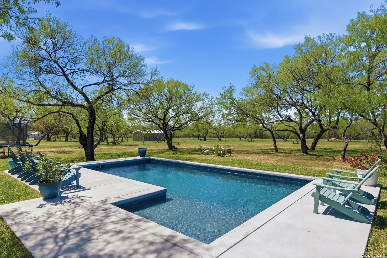 105 Old Campbell Road Seguin, TX 78155 - Photo 35 of 49 a view of a backyard with lawn chairs under an umbrella