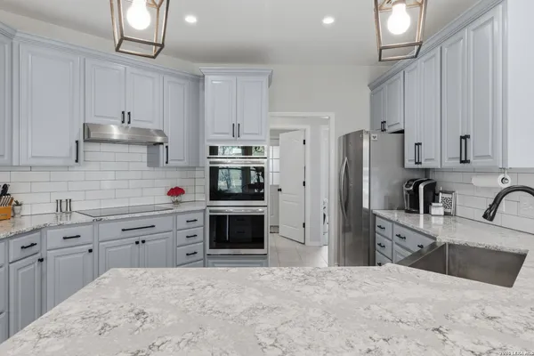 a kitchen with stainless steel appliances a refrigerator sink and cabinets