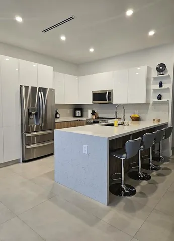 a kitchen with stainless steel appliances a stove a sink a refrigerator and cabinets