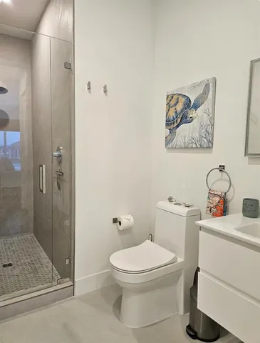 a bathroom with a toilet a sink and glass door