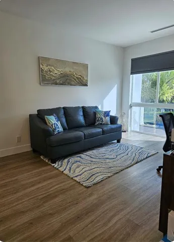 a living room with furniture window and wooden floor