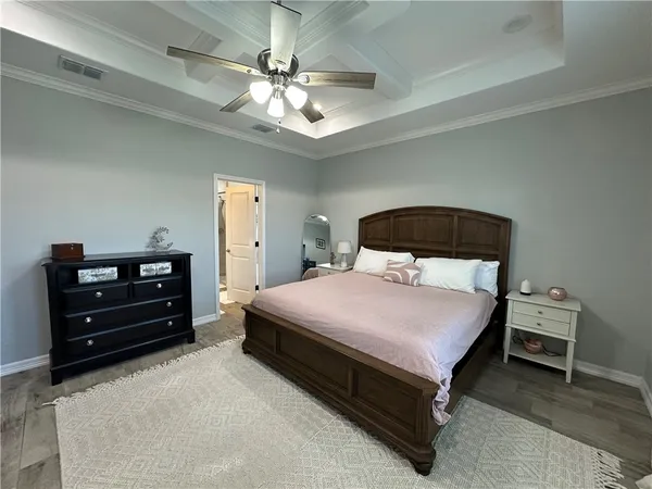 a bedroom with a bed and a flat tv screen on dresser