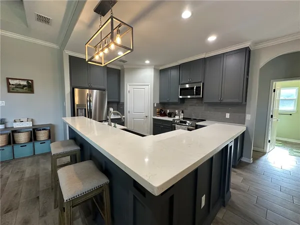 a kitchen with a dining table chairs and refrigerator