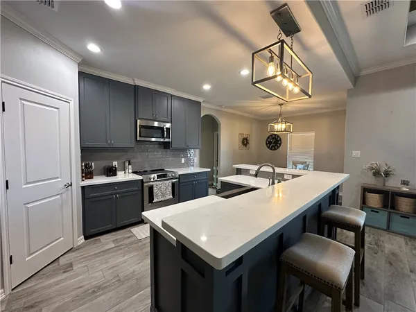 a kitchen with a table chairs microwave and cabinets