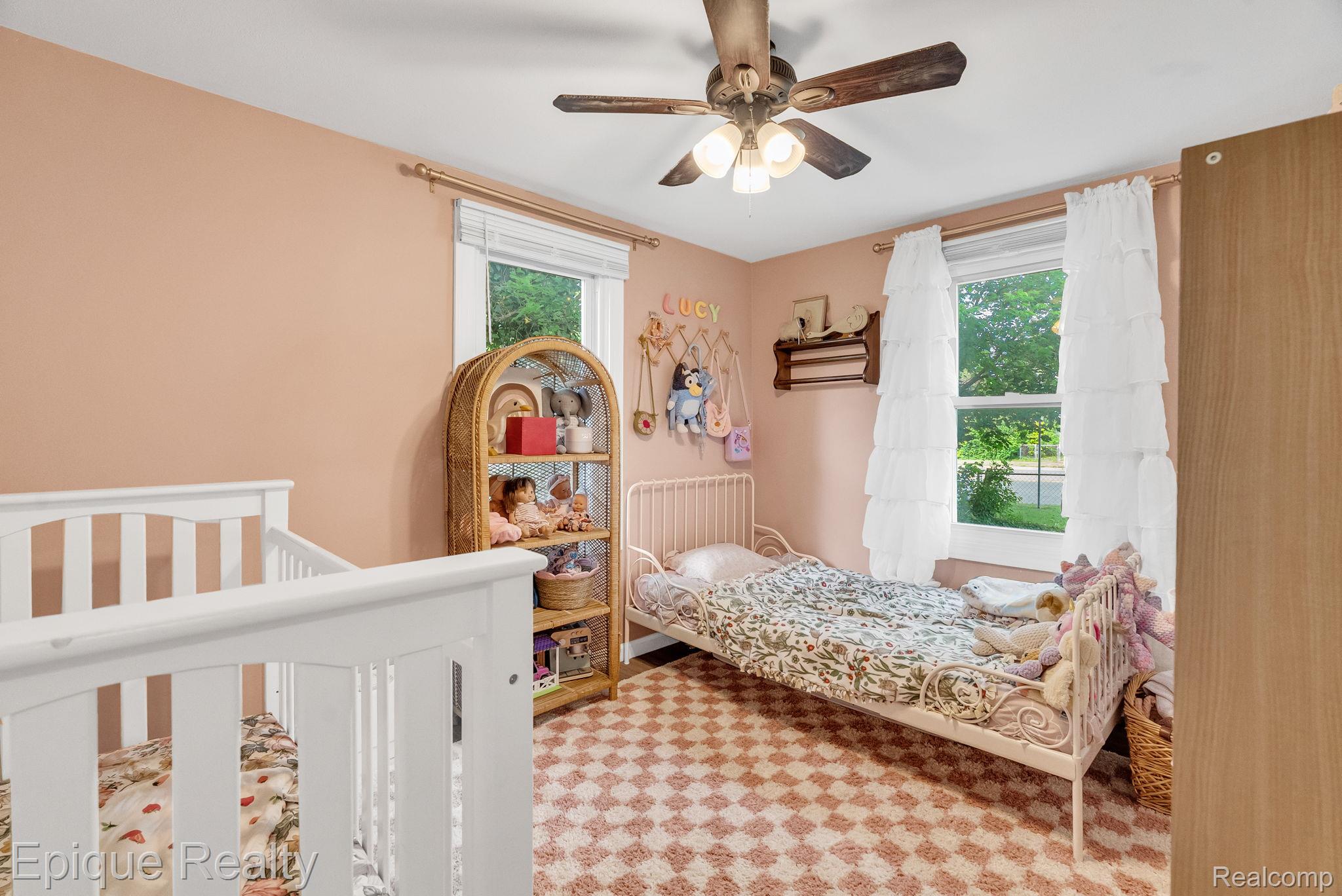 2182 North Center Road Burton, MI 48509 - Photo 27 of 34 Bedroom featuring a ceiling fan with integrated lighting, two windows with white trim, and a patterned area rug