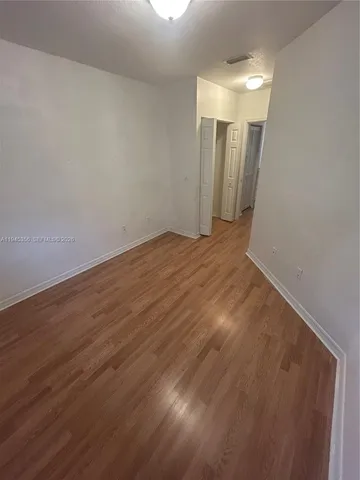 a view of a room with wooden floor and white walls