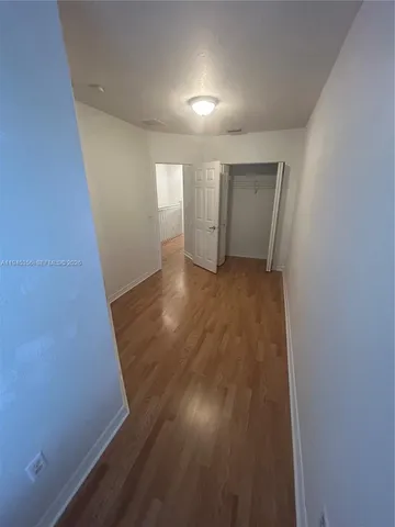 an empty room with wooden floor and closet