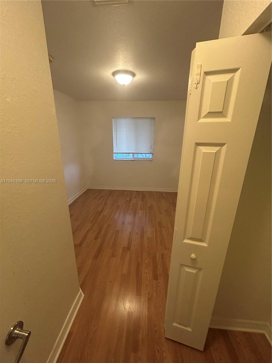 1916 Alamanda Way Riviera Beach, FL 33404 - Photo 17 of 22 an empty room with wooden floor and closet