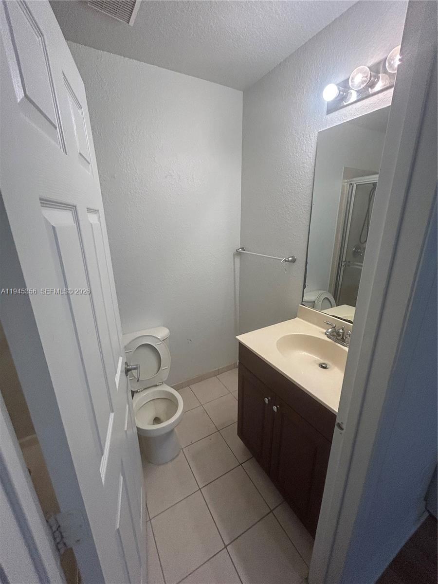 1916 Alamanda Way Riviera Beach, FL 33404 - Photo 19 of 22 a bathroom with a granite countertop sink toilet and shower
