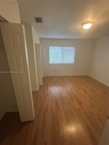an empty room with wooden floor and closet