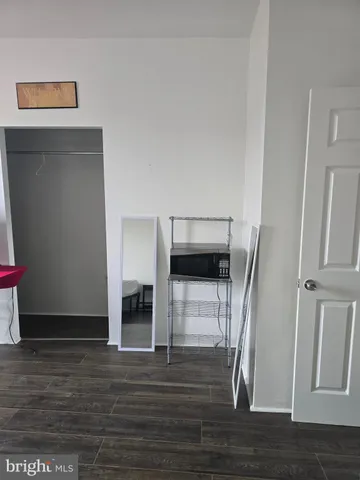 a view of a livingroom with wooden floor and a refrigerator