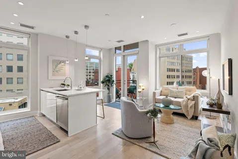 a living room with furniture a large window and a rug