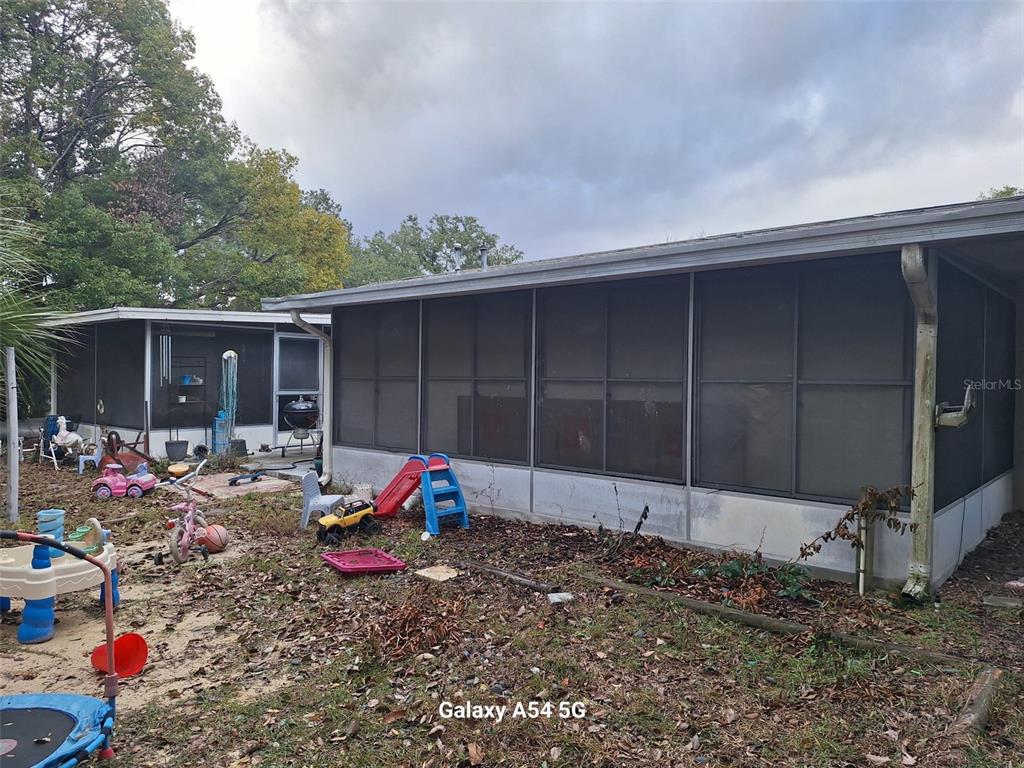 3762 Southwest 150th Loop Ocala, FL 34473 - Photo 24 of 25 a backyard of a house with barbeque oven table and chairs