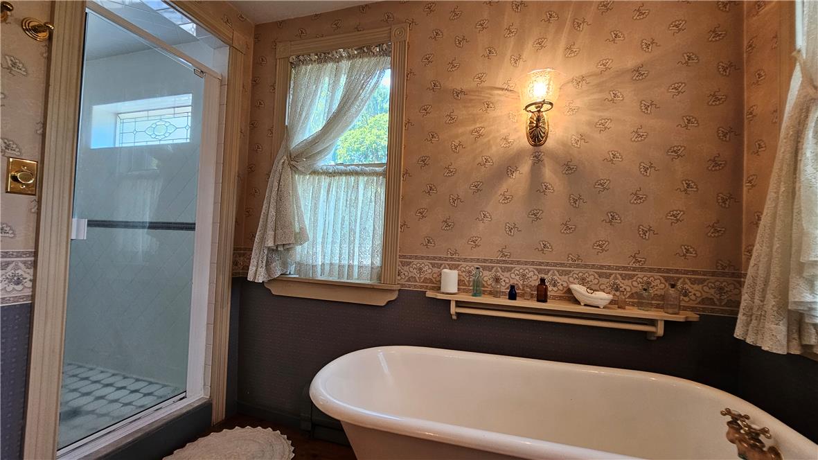 585 Buttermilk Road Hellertown, PA 18055 - Photo 36 of 82 A classic clawfoot tub anchors this elegant bathing retreat with intricate wall coverings and a glass-enclosed shower.
