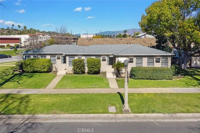 a view of a big house with a big yard and potted plants