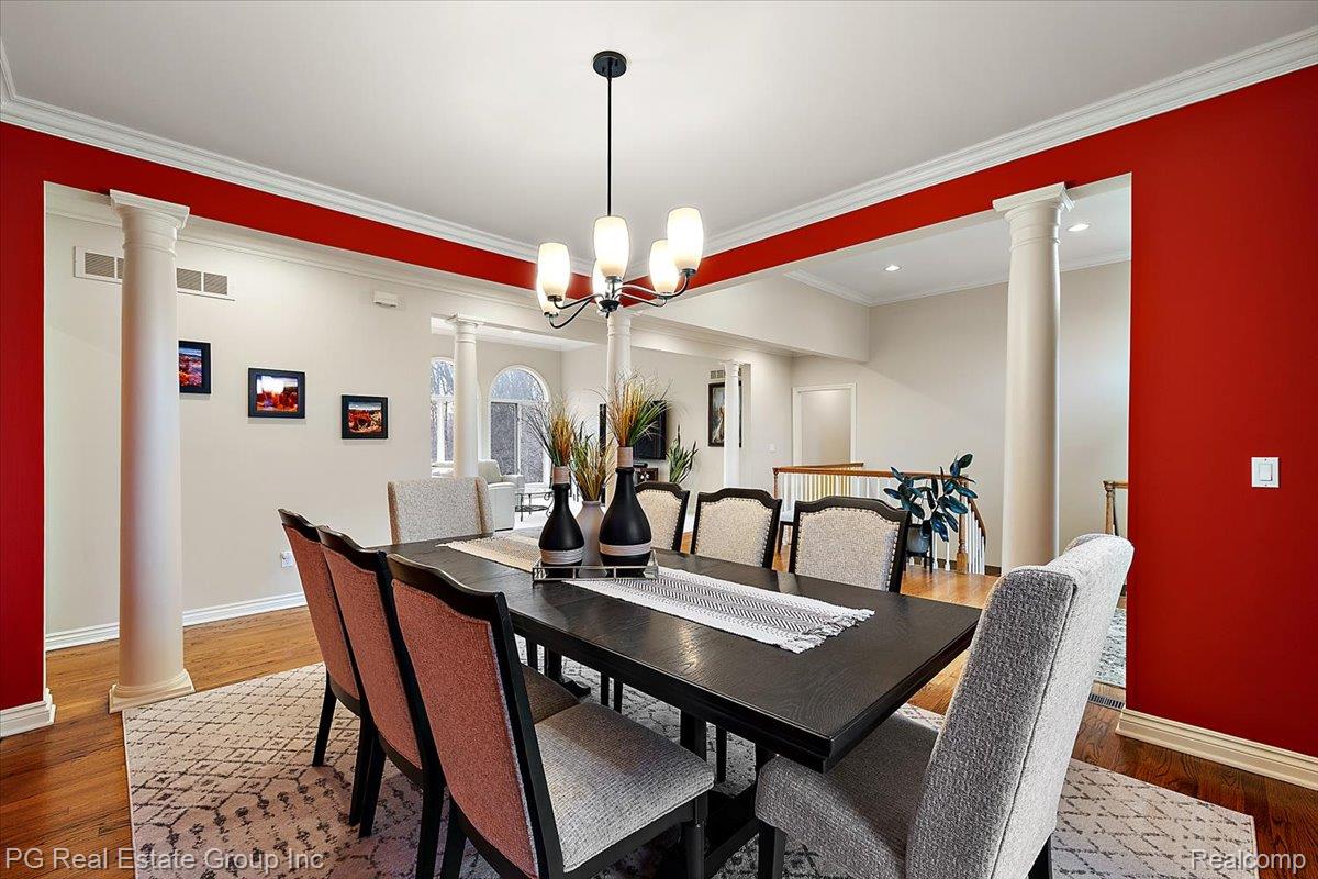 3571 Cedar Brook Drive Rochester, MI 48309 - Photo 23 of 57 Dining space with decorative columns, suspended lighting, wood finished floors, and ornamental molding