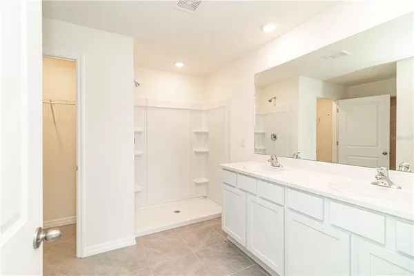 a bathroom with a double vanity sink mirror double and shower