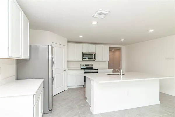 a kitchen with stainless steel appliances a refrigerator stove and microwave