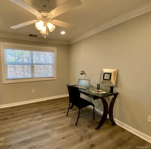 a view of a workspace with furniture and a window