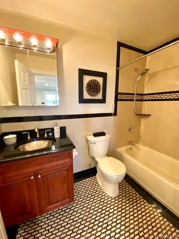 a bathroom with a granite countertop sink a toilet a mirror and a shower