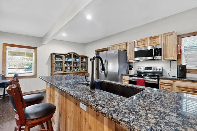 a kitchen with stainless steel appliances cabinets and a wooden floor