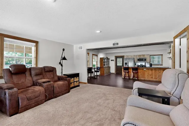 a living room with furniture a flat screen tv and a large window