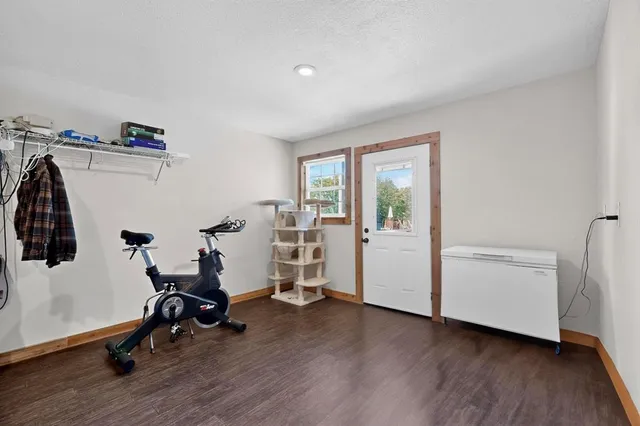 a view of an empty room with wooden floor and closet
