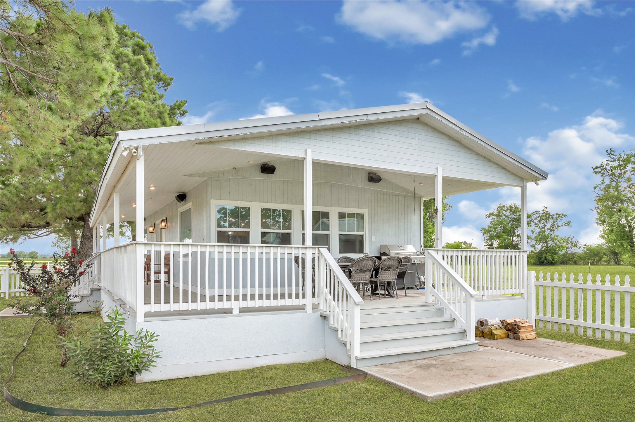 868 Lisa May Road Bellville, TX 77418 - Photo 12 of 39 Spacious wrap-around porch on two sides of the cabin offers plenty of room to relax and enjoy peaceful views of the surrounding acreage.