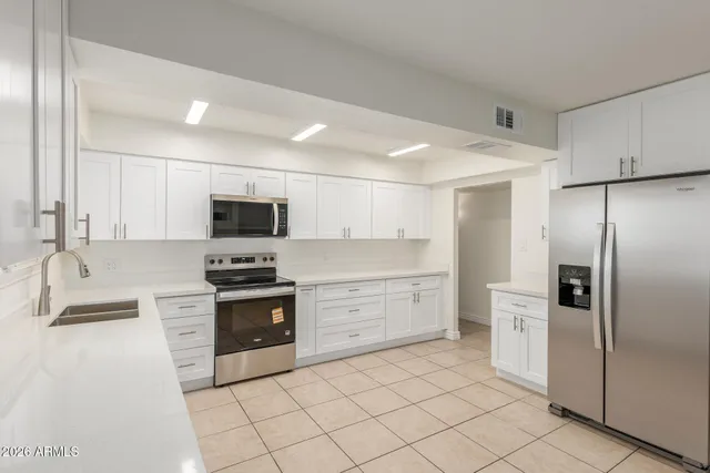 a kitchen with a sink stainless steel appliances and cabinets