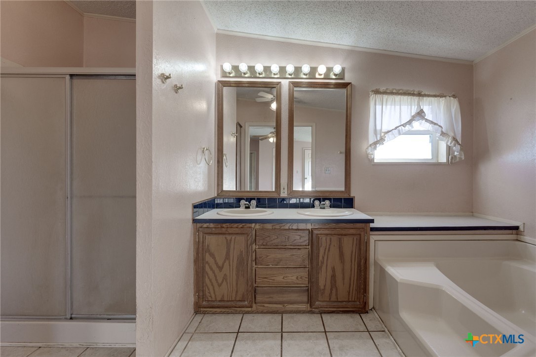809 Crest Court Copperas Cove, TX 76522 - Photo 15 of 22 a view of a bathroom with a bathtub a sink and a mirror
