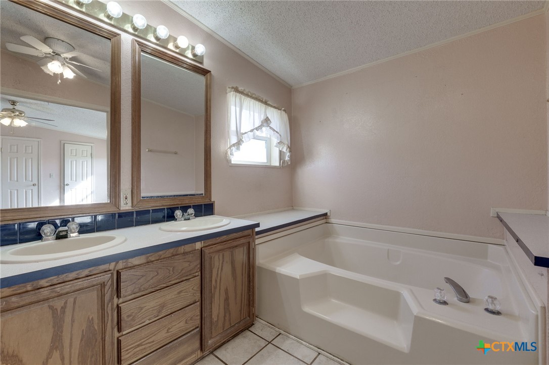 809 Crest Court Copperas Cove, TX 76522 - Photo 16 of 22 a bathroom with a tub sink and mirror