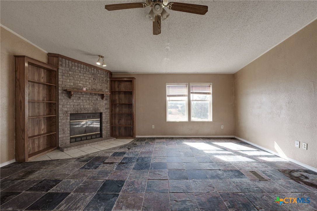 809 Crest Court Copperas Cove, TX 76522 - Photo 6 of 22 a view of a livingroom with a fireplace a ceiling fan and windows